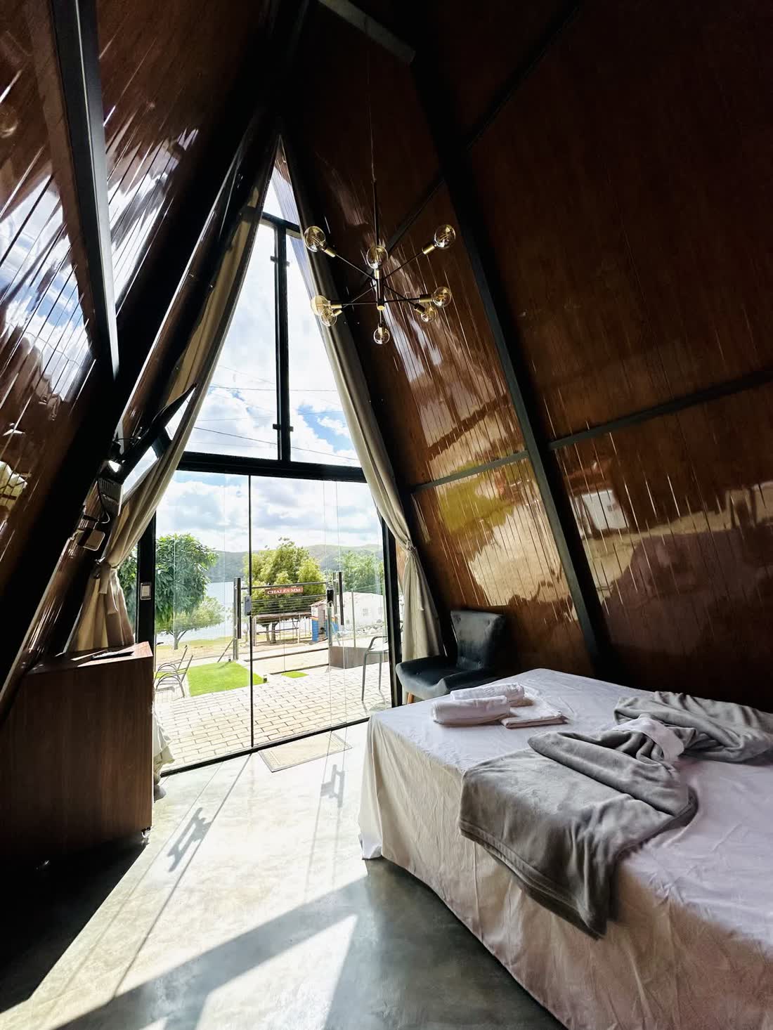 Interior do chalé com cama e parede de tijolo aparente